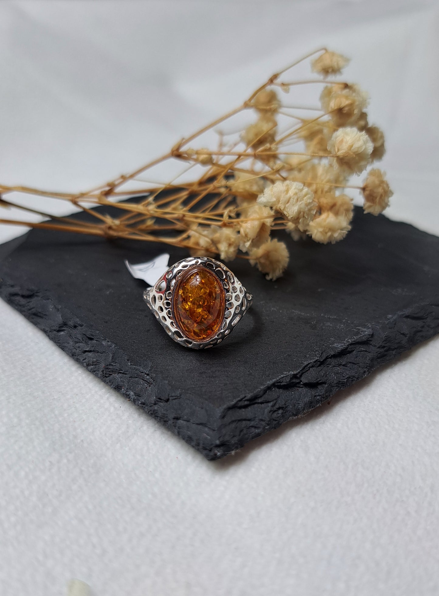 Oval cognac amber with a decorative openwork design on the shoulders