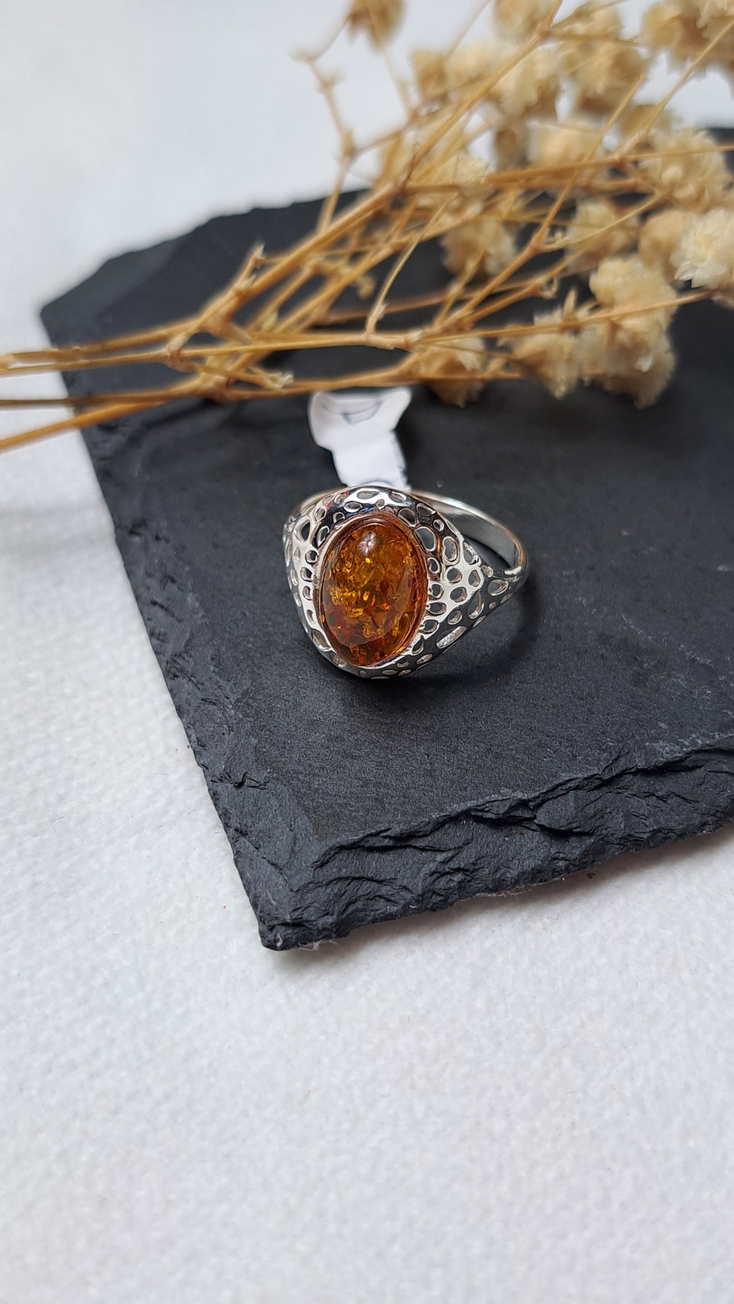 Oval cognac amber with a decorative openwork design on the shoulders