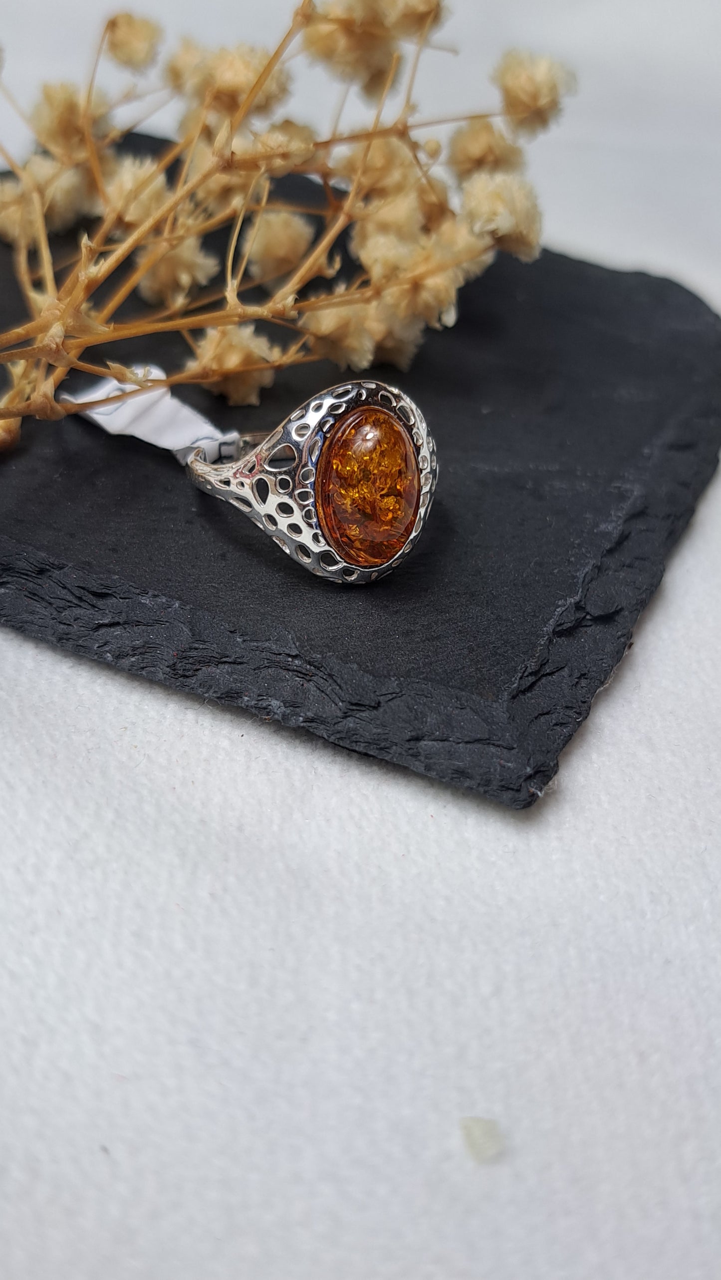 Oval cognac amber with a decorative openwork design on the shoulders
