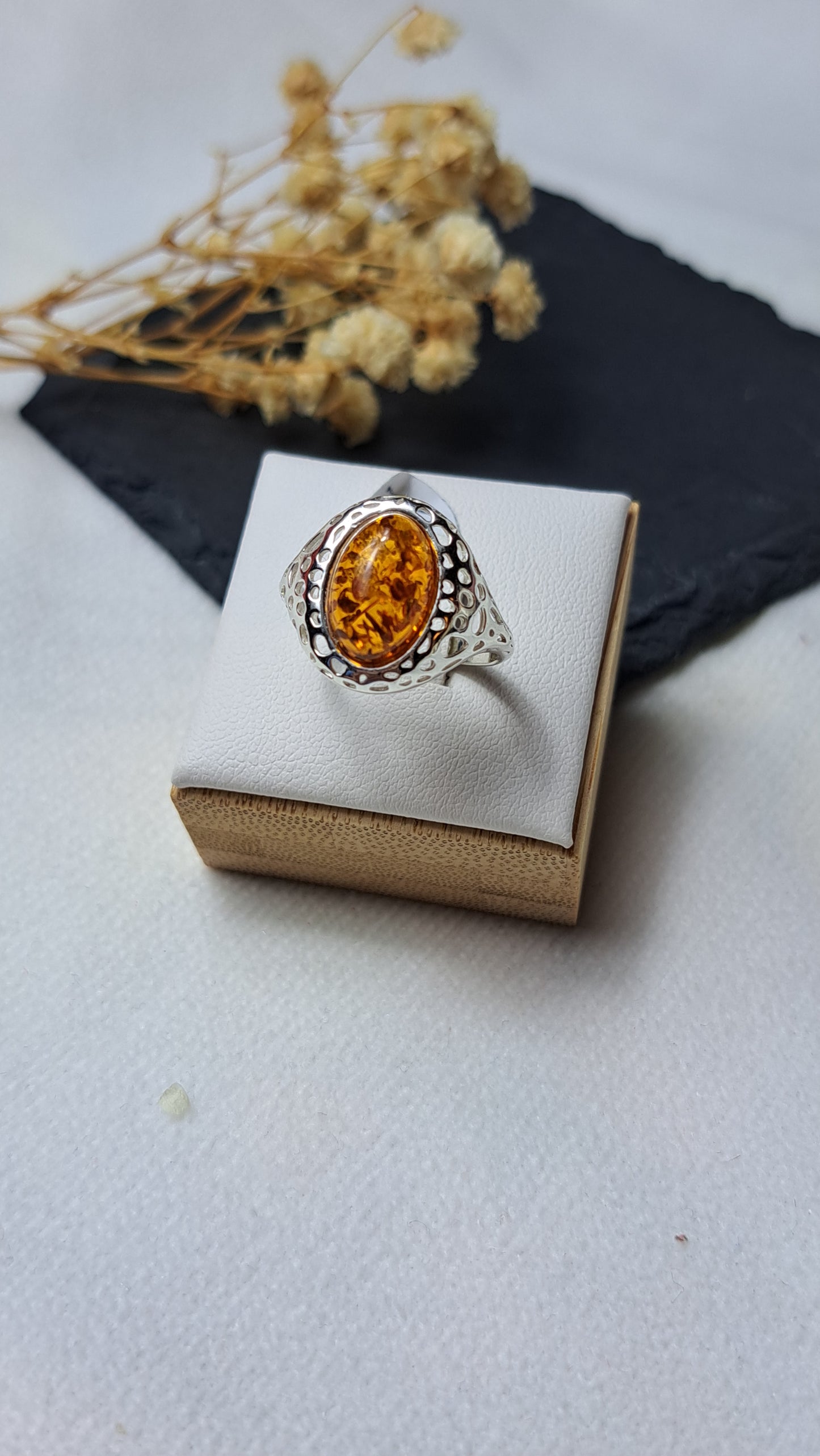 Oval cognac amber with a decorative openwork design on the shoulders