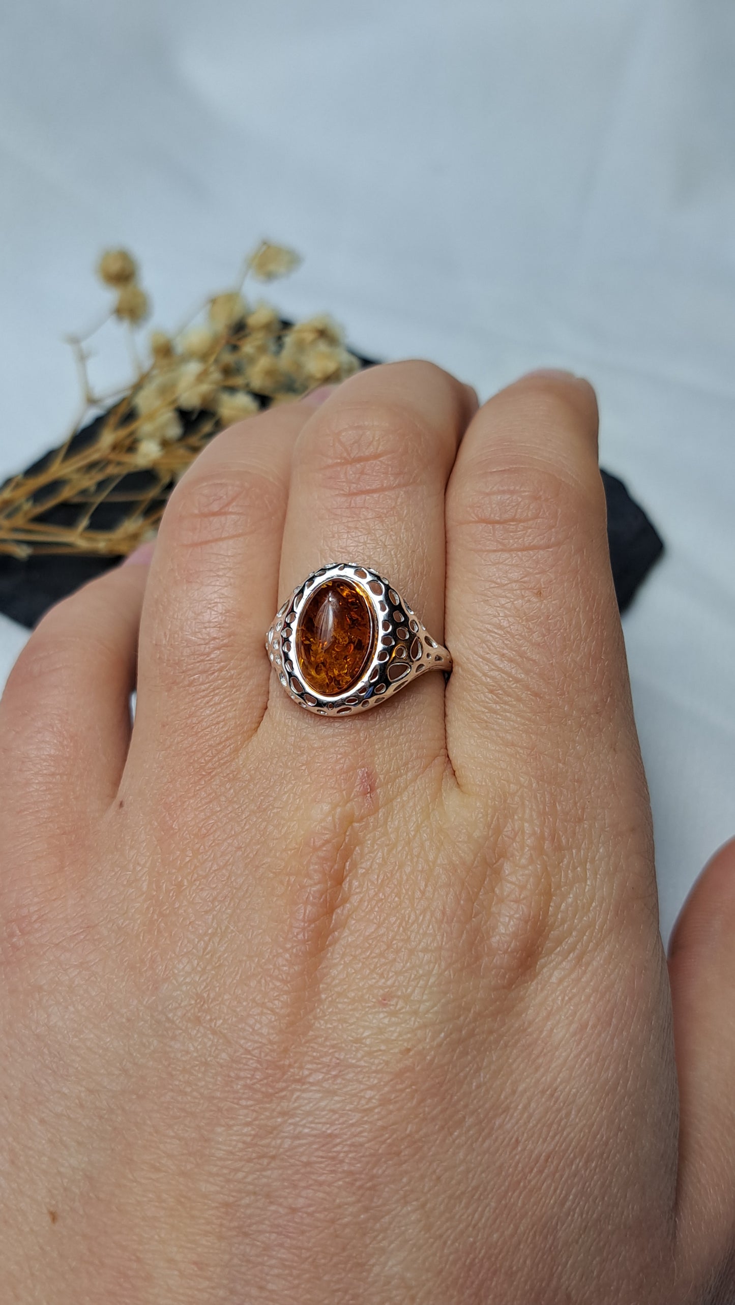 Oval cognac amber with a decorative openwork design on the shoulders